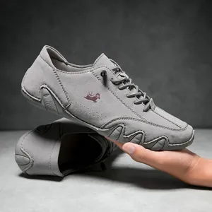 Detail of dark grey suede casual shoes showing red goat logo and anti-slip sole blocks