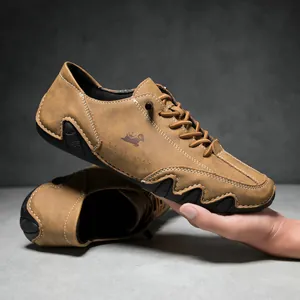 Close-up of brown suede casual shoes featuring white hand-stitched seams and rubber sole