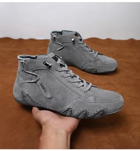 Detailed side view of men's high-top gray suede boots with durable wave-patterned rubber soles