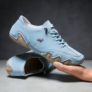 Detail of light blue suede casual shoe featuring wave-textured sole and crown logo