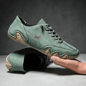 Detail of green suede leather men's shoe featuring white stitching and rugged rubber sole
