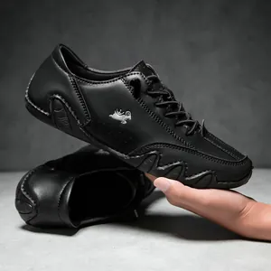 Detailed side view of a black leather casual shoe featuring a silver goat logo and wavy sole