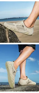 Detail of khaki men's mesh outdoor shoe with rubber sole on beach rocks and sand