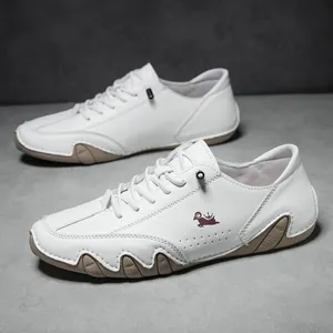 Detail of white leather low-top shoes with ram logo and wavy brown rubber sole