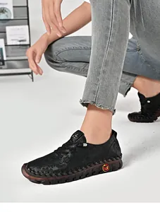 Detail of black flat walking shoes featuring floral texture and non-slip rubber sole