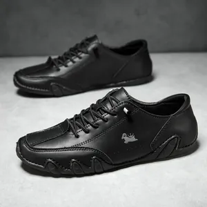 Close-up of black low-top leather shoes with wave-patterned soles and silver logo detail