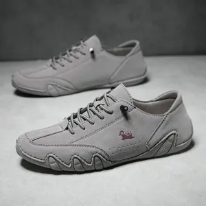 Detailed macro view of gray suede men's shoe featuring a red logo and anti-slip sole texture