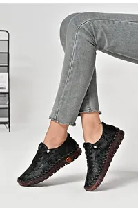 Detail of floral embossed black leather upper on thick non-slip rubber sole shoes