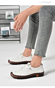 Detail of hand-stitched white leather shoes with thick rubber soles and woven edge