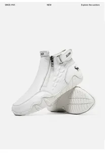 Detail of white high-top leather boots featuring crocodile texture and side zipper