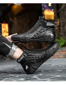 Detail of black crocodile embossed leather boots with side zipper and velcro strap