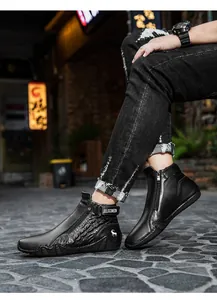 Detailed view of black leather ankle boots featuring side zipper and embossed texture
