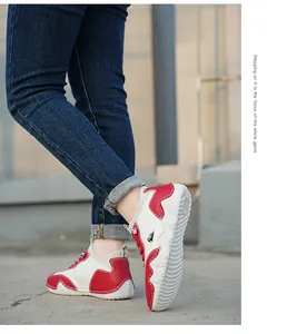 Detailed view of children's red and white leather sneakers with non-slip rubber outsoles