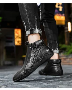 Low angle view of black leather high-top boots featuring embossed textures and side zipper