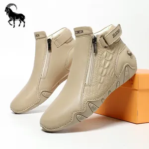 Detail view of beige leather high-top boots with crocodile texture and side zipper