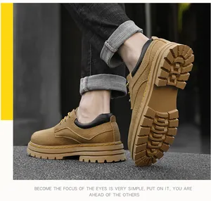 Detail view of tan leather work shoes featuring bold yellow stitching and thick rubber soles