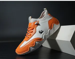 Detailed view of white and orange leather sneaker featuring wavy thick sole and logo