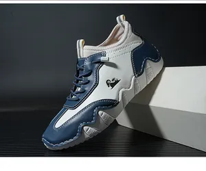 Detail of blue and white leather casual sneakers with contrast stitching and goat logo