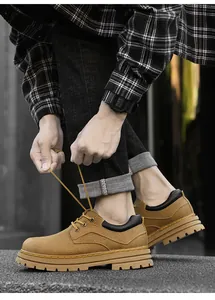 Detailed view of camel leather work boots with yellow stitching and rugged rubber sole