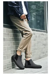 Détail de bottine Chelsea en daim gris foncé avec pantalon kaki et semelle épaisse crantée