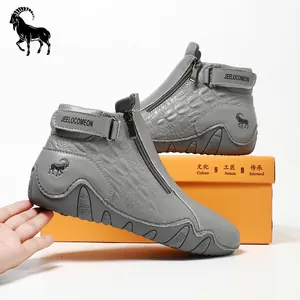 Detail of grey leather boots with crocodile texture, metal zipper and brand logo
