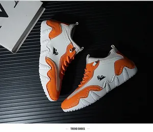 Detailed side view of orange and white synthetic leather sneakers with logo