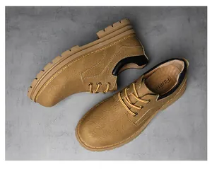 Overhead shot of khaki leather work boots with yellow laces and heavy-duty rubber soles