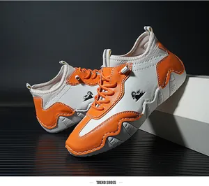 Detail shot of orange and white casual sneakers with goat logo and serrated thick sole