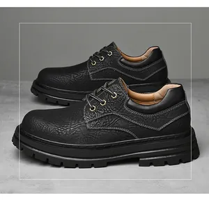 Detail of black pebbled leather low-top boots with white contrast stitching and thick soles