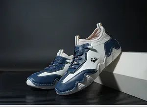 Detail of navy and white leather sneakers with wavy rubber sole and contrast stitching