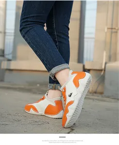 Detail of orange and beige casual sneakers featuring thick wavy non-slip soles on a model