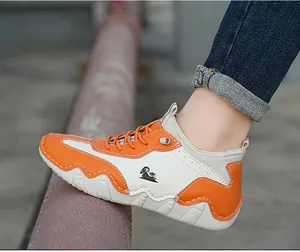 Outdoor shot of men's hiking shoes with orange and cream contrast panels and thick wavy soles