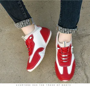 Top-down view of white and red leather mid-top sneakers with detailed stitching