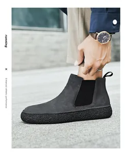 Détail de bottines Chelsea en daim gris foncé avec panneaux élastiques et semelle épaisse