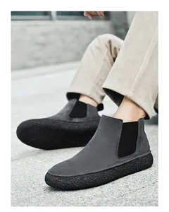 Détail de bottines Chelsea en daim gris foncé avec panneaux élastiques et semelles épaisses