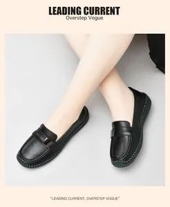 Primer plano de mocasines de cuero negro con hebilla metálica y costuras trenzadas