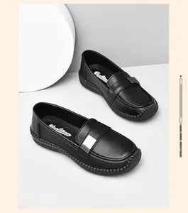 Detalle de mocasines de cuero negro con hebilla plateada y suela de goma cosida