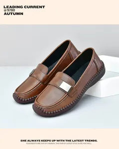 Detalle de mocasines de cuero marrón con hebilla plateada y costura artesanal a mano