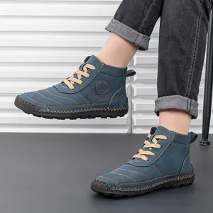 Detail of grey-blue lace-up Martin boots showing rugged stitching and thick rubber sole