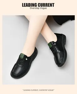 Detail of black leather loafers with green tongue accent and handmade stitching seams