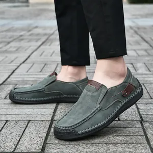 Men's dark green suede loafers with hand-stitched detailing and black rubber soles