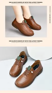 Detail shot of caramel leather loafers with green tongue accent and contrast stitching