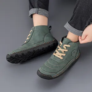 Detailed view of dark green suede work boots with cream laces and durable stitched rubber soles