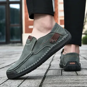 Detail of gray-green suede loafers featuring contrast stitching and rubber sole protection