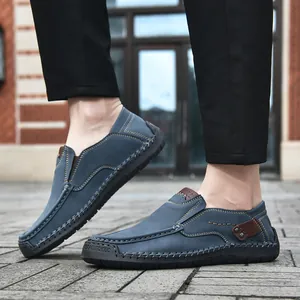 Close-up of blue loafers featuring hand-stitched details and durable rubber outsoles