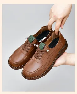 Detail of hand-stitched seams and green leather patch on brown leather casual shoes