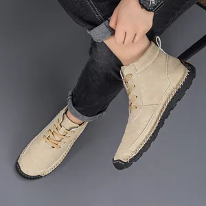 Detailed view of handmade stitching on men's khaki martin boots with black rubber soles