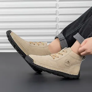 Close-up of khaki suede boots with durable non-slip rubber soles and logo detail