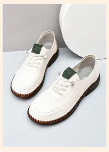 Close-up of off-white leather loafers showing the non-slip rubber sole and logo detail