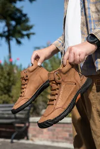 Detail of brown PU leather boot showing hand-stitched seams and textured rubber sole